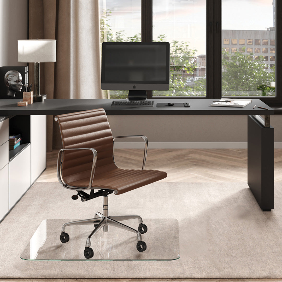 #glass clarity_luminoso (low-iron ultra clear) alt="Modern home office with a black desk, computer. A brown leather chair on a 36" x 42" "luminoso" glass chair mat on a light rug."